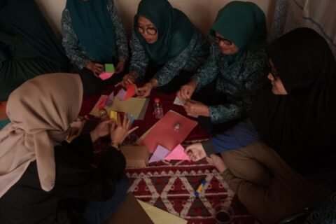 Suasana interaktif saat tim mahasiswa dan dosen Desain Interior UPN "Veteran" Jawa Timur memberikan pendampingan langsung kepada warga dalam menaklukkan kerumitan pola lipatan Origami Lamp.