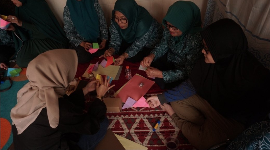 Suasana interaktif saat tim mahasiswa dan dosen Desain Interior UPN "Veteran" Jawa Timur memberikan pendampingan langsung kepada warga dalam menaklukkan kerumitan pola lipatan Origami Lamp.