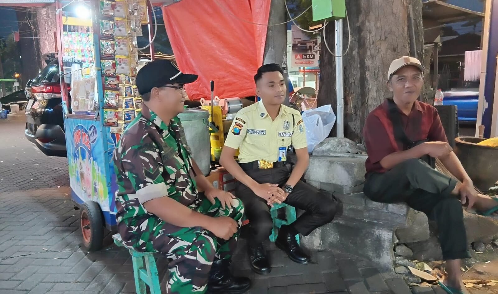 Babinsa Kelurahan Klojen Sertu Gunawan berbincang hangat bersama petugas keamanan (Satpam) dan warga di sela-sela kegiatan patroli dialogis malam di wilayah Klojen, Kota Malang. (Foto: Dok. Koramil 0833-01/Klojen)