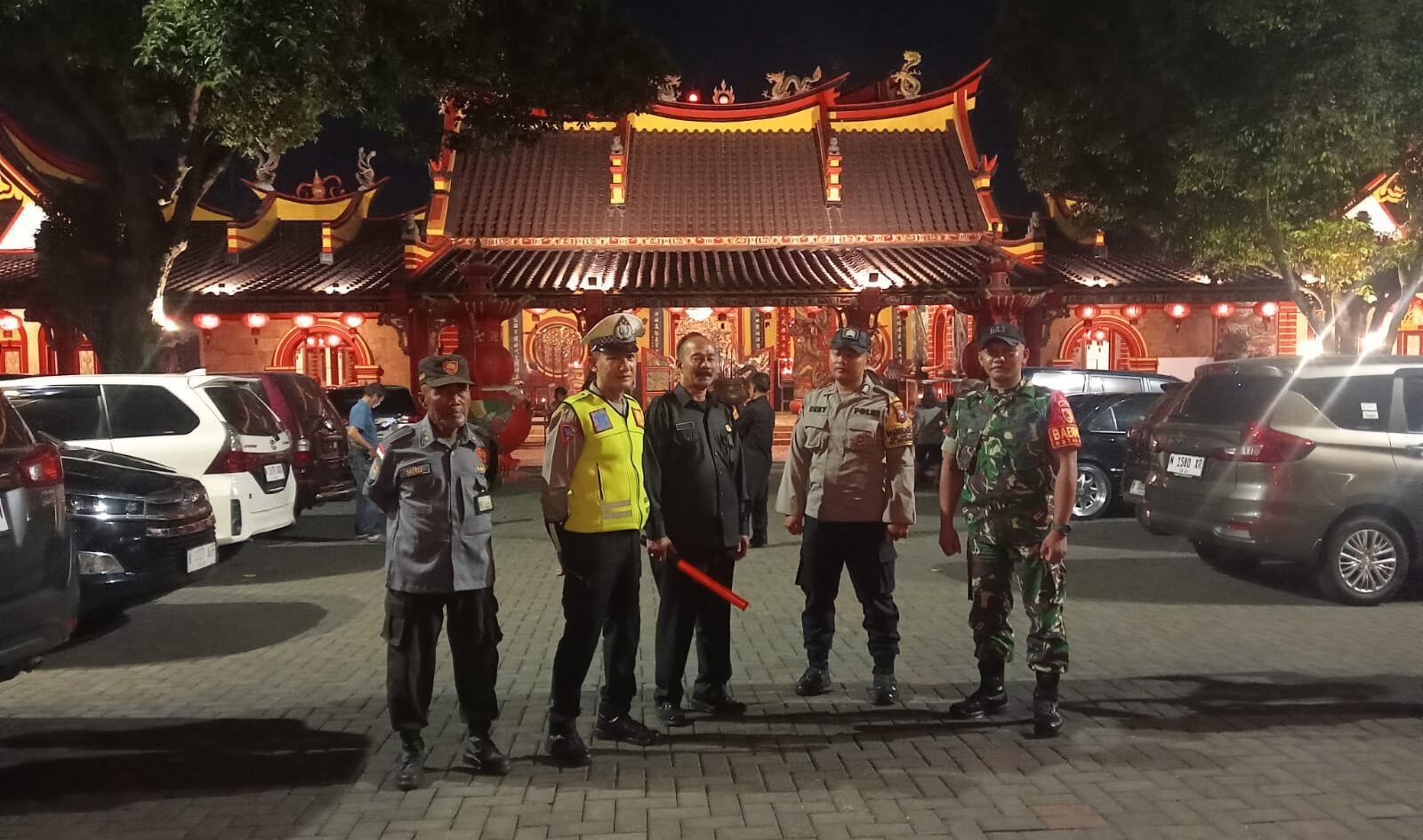 Babinsa Kelurahan Kotalama Koptu Eko bersama aparat kepolisian dan petugas keamanan berjaga di halaman Klenteng Eng An Kiong demi memastikan situasi lingkungan tetap kondusif di Kota Malang.