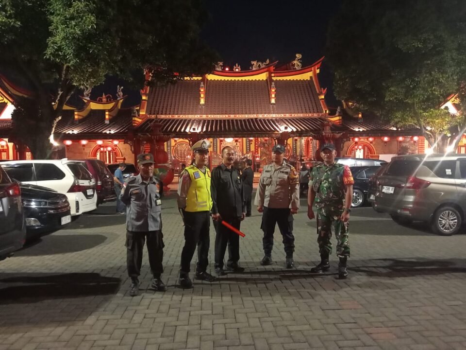 Babinsa Kelurahan Kotalama Koptu Eko bersama aparat kepolisian dan petugas keamanan berjaga di halaman Klenteng Eng An Kiong demi memastikan situasi lingkungan tetap kondusif di Kota Malang.