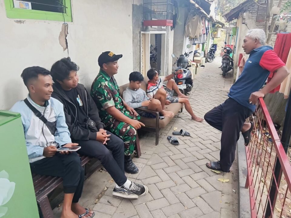 Babinsa Koramil 0833-01/Klojen, Sertu Gunawan, tampak membaur dan bercengkerama santai bersama warga di sebuah gang permukiman Kelurahan Klojen, Rabu (16/09/2026).