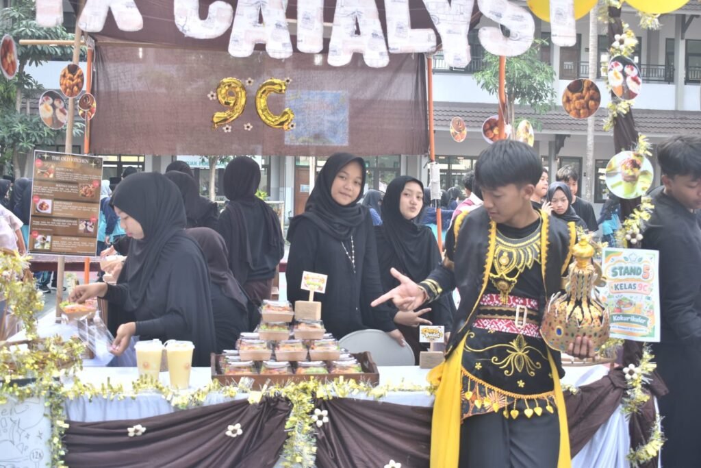 Murid kelas 9 MTs Almaarif 01 Singosari antusias mempromosikan produk market day mereka dengan kostum kreatif di stan "IX Catalyst" pada Karya Kerenfest 2026, belajar menjadi entrepreneur muda.