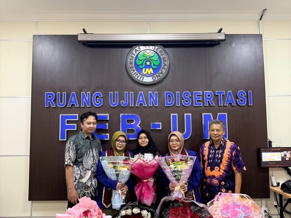 Dr. Durinda Puspasari dan Dr. Durinta Puspasari (tengah) memegang buket bunga kebanggaan usai dinyatakan lulus dalam ujian disertasi Program Doktor Pendidikan Ekonomi di Ruang Ujian Disertasi FEB Universitas Negeri Malang (UM).