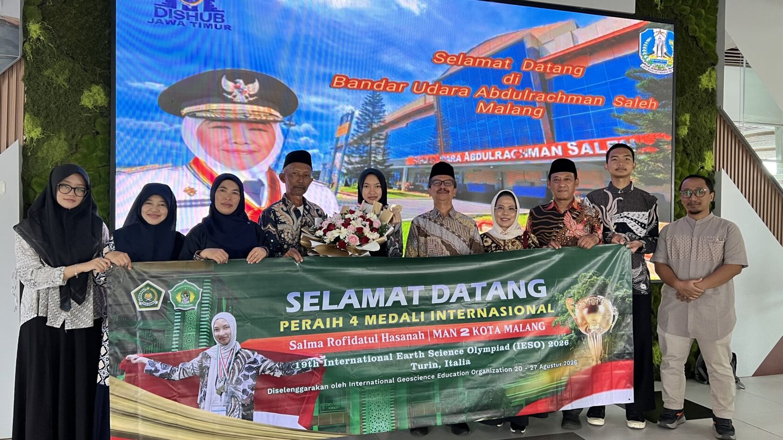 Suasana penyambutan Salma Rofidatul Hasanah (membawa buket bunga), siswi kelas XII G MAN 2 Kota Malang, setibanya di Bandara Abdurrahman Saleh, Malang.