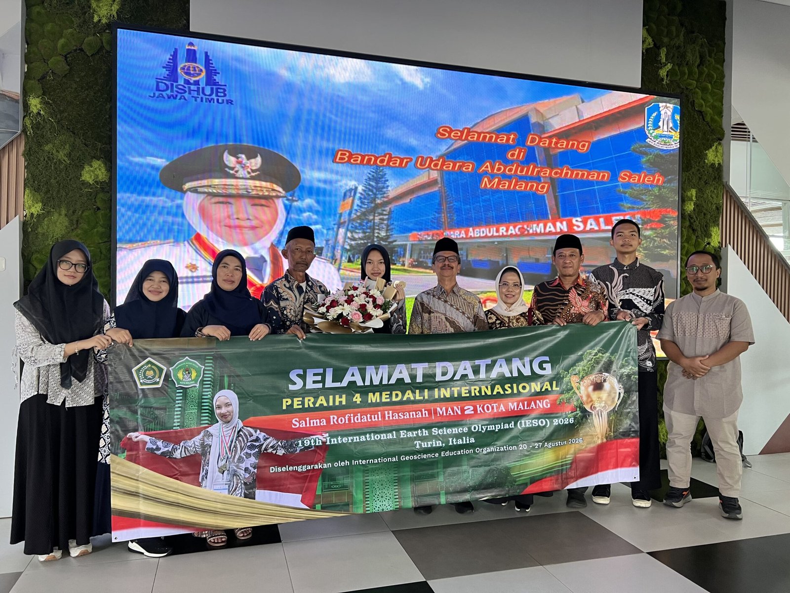 Suasana penyambutan Salma Rofidatul Hasanah (membawa buket bunga), siswi kelas XII G MAN 2 Kota Malang, setibanya di Bandara Abdurrahman Saleh, Malang.