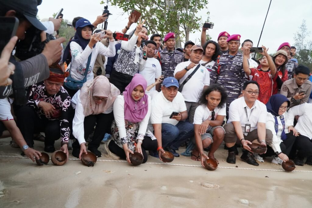 Anggota DPD RI Dr. Lia Istifhama (tengah berkerudung ungu) bersama Kaka Slank dan jajaran pejabat lintas instansi berjongkok bersiap melepasliarkan tukik ke laut dalam Safari Perhutanan Sosial di Pantai Tanjung Penyu, Kabupaten Malang, Sabtu (26/9/2026).