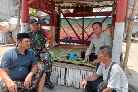 Babinsa Kotalama, Koptu Eko (berjaket loreng), tampak duduk bersama dan berbincang santai penuh kekeluargaan ditemani secangkir kopi bersama sejumlah warga di sebuah pos wilayah Kelurahan Kotalama, Kecamatan Kedungkandang, Kota Malang, Kamis (17/09/2026).