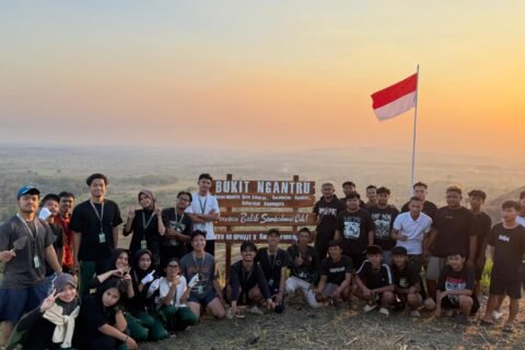 Mahasiswa KKN Kelompok 60 bersama anggota Karang Taruna Dusun Ngantru berfoto di depan plang penanda yang baru dipasang di puncak Bukit Ngantru, Desa Sekaran, Kecamatan Kasiman, Kabupaten Bojonegoro.