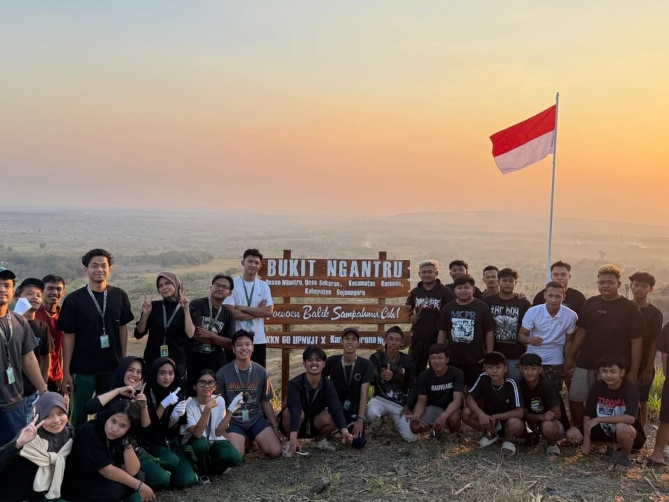 Mahasiswa KKN Kelompok 60 bersama anggota Karang Taruna Dusun Ngantru berfoto di depan plang penanda yang baru dipasang di puncak Bukit Ngantru, Desa Sekaran, Kecamatan Kasiman, Kabupaten Bojonegoro.