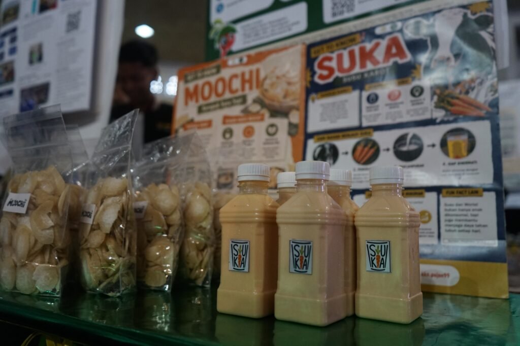 Inovasi Olahan Susu: Tampilan visual dari produk UMKM rintisan, yakni minuman botol SUKA (Susu Karot) dan kerupuk renyah MOOCHI hasil kreasi Kelompok 99 KKN MAs UMM yang dipamerkan pada ajang Expo Kecamatan Pujon, Kabupaten Malang.