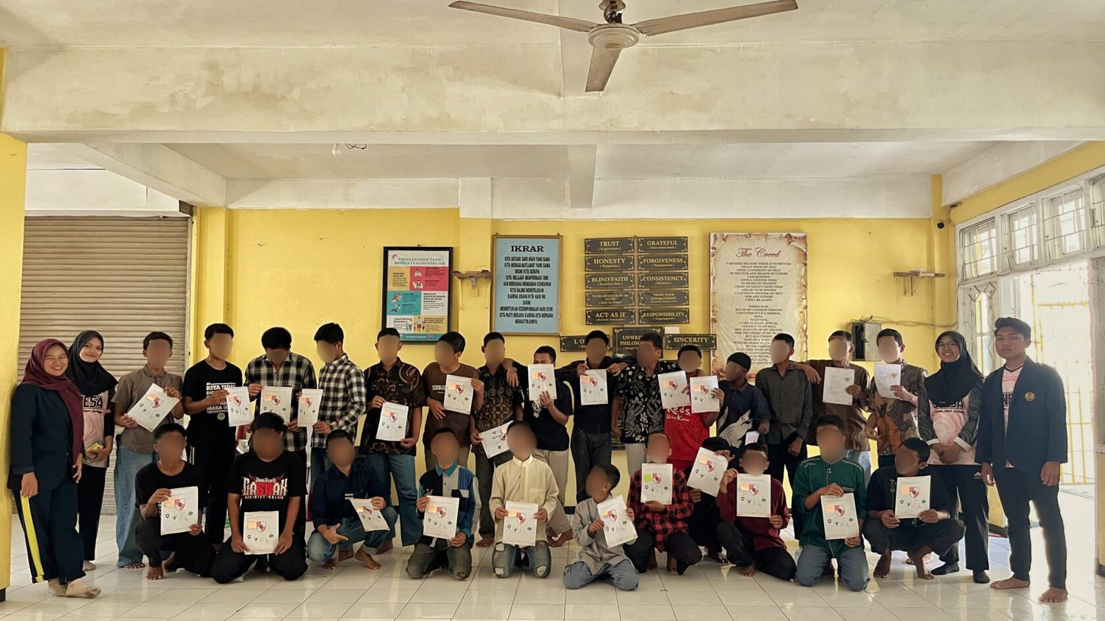 Anak PM bersama Mahasiswa PPKn berfoto bersama sembari menunjukkan hasil pengerjaan Lembar Kerja Peserta Didik (LKPD) seusai mengikuti kegiatan pembelajaran interaktif mengenai penerapan nilai-nilai Pancasila di UPT PRSMPS Surabaya, Rabu (2/9/2026).