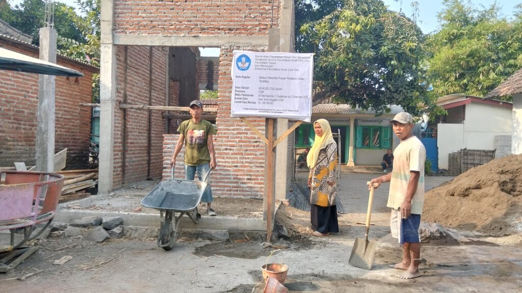 Pengerjaan proyek revitalisasi KB Roudhotul Hasan Lajuk lengkap dengan papan informasi kegiatan bantuan pemerintah.