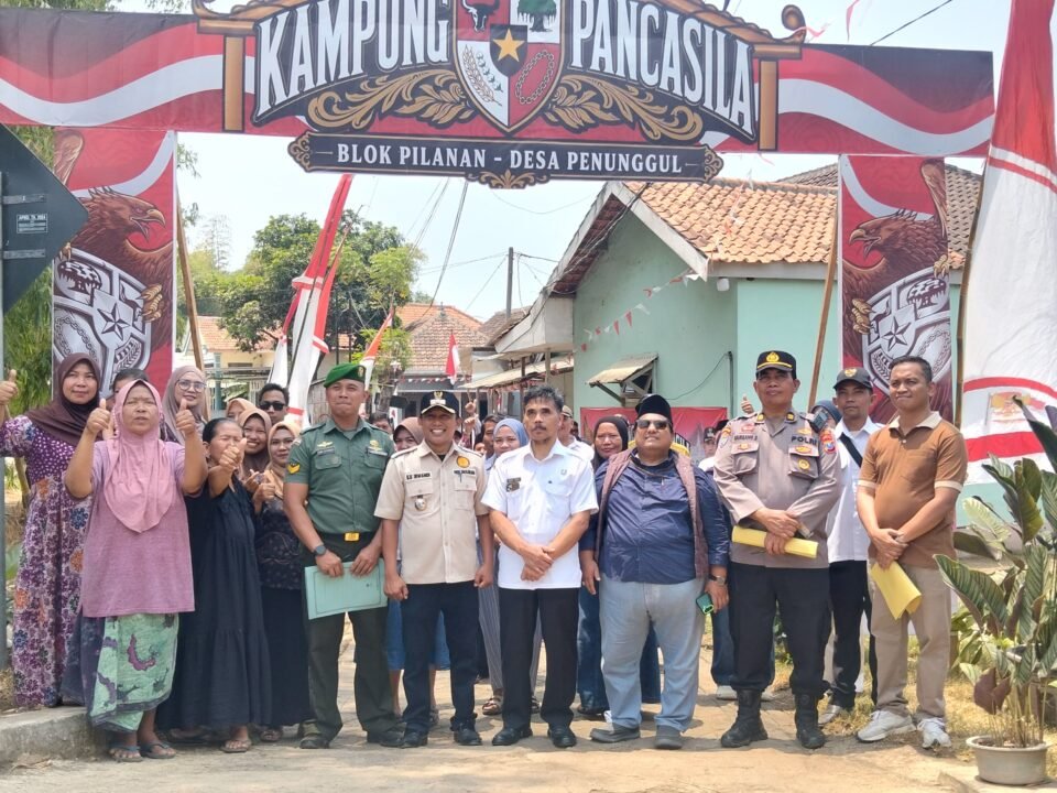 Potret antusiasme dan kebersamaan warga bersama elemen pemerintah desa, TNI, serta Polri di bawah gapura Blok Pilanan saat menyambut tim penilai Lomba Kampung Pancasila di Desa Penunggul.