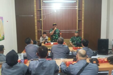 Babinsa Kelurahan Klojen Sertu Gunawan berdiri memberikan arahan dan pembekalan tugas ketertiban wilayah kepada anggota Satlinmas di aula pertemuan, Klojen, Kota Malang.