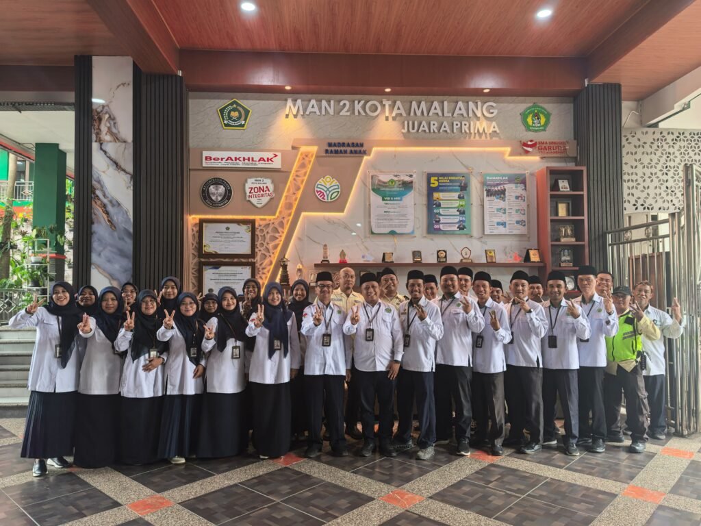 Kepala MAN 2 Kota Malang Dr. H. Samsudin, M.Pd. bersama Kepala TU H. Sugeng Winarto, M.Pd. dan jajaran Tenaga Kependidikan (Tendik) berfoto bersama usai Apel Rutin Triwulan di depan Gedung PTSP MAN 2 Kota Malang, Senin (28/9).