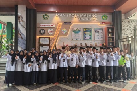 Kepala MAN 2 Kota Malang Dr. H. Samsudin, M.Pd. bersama Kepala TU H. Sugeng Winarto, M.Pd. dan jajaran Tenaga Kependidikan (Tendik) berfoto bersama usai Apel Rutin Triwulan di depan Gedung PTSP MAN 2 Kota Malang, Senin (28/9).