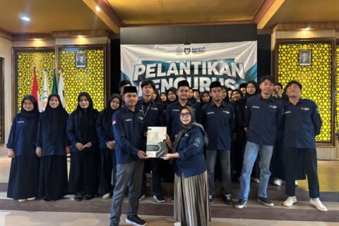 Ketua Program Studi PAI UNU Pasuruan, Ning Mukaromah, menyerahkan dokumen secara simbolis kepada Ketua HMPS PAI terpilih, Burham, didampingi jajaran pengurus baru usai prosesi pelantikan periode 2026/2027 di Gedung ITC.