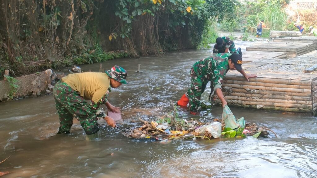 Anggota Koramil 0833-01/Klojen terjun langsung ke aliran sungai untuk membersihkan sampah yang menumpuk bersama warga di kawasan Kelurahan Kauman, Kecamatan Klojen, Kota Malang, Sabtu (19/9/2026).