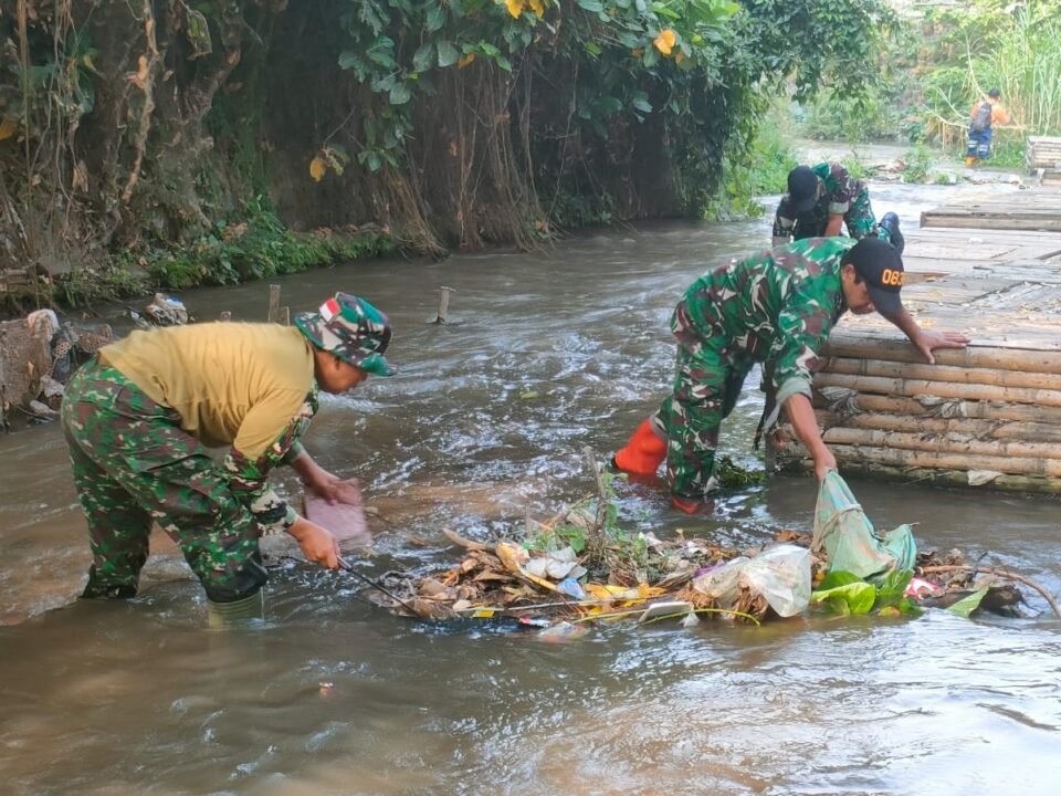 Anggota Koramil 0833-01/Klojen terjun langsung ke aliran sungai untuk membersihkan sampah yang menumpuk bersama warga di kawasan Kelurahan Kauman, Kecamatan Klojen, Kota Malang, Sabtu (19/9/2026).