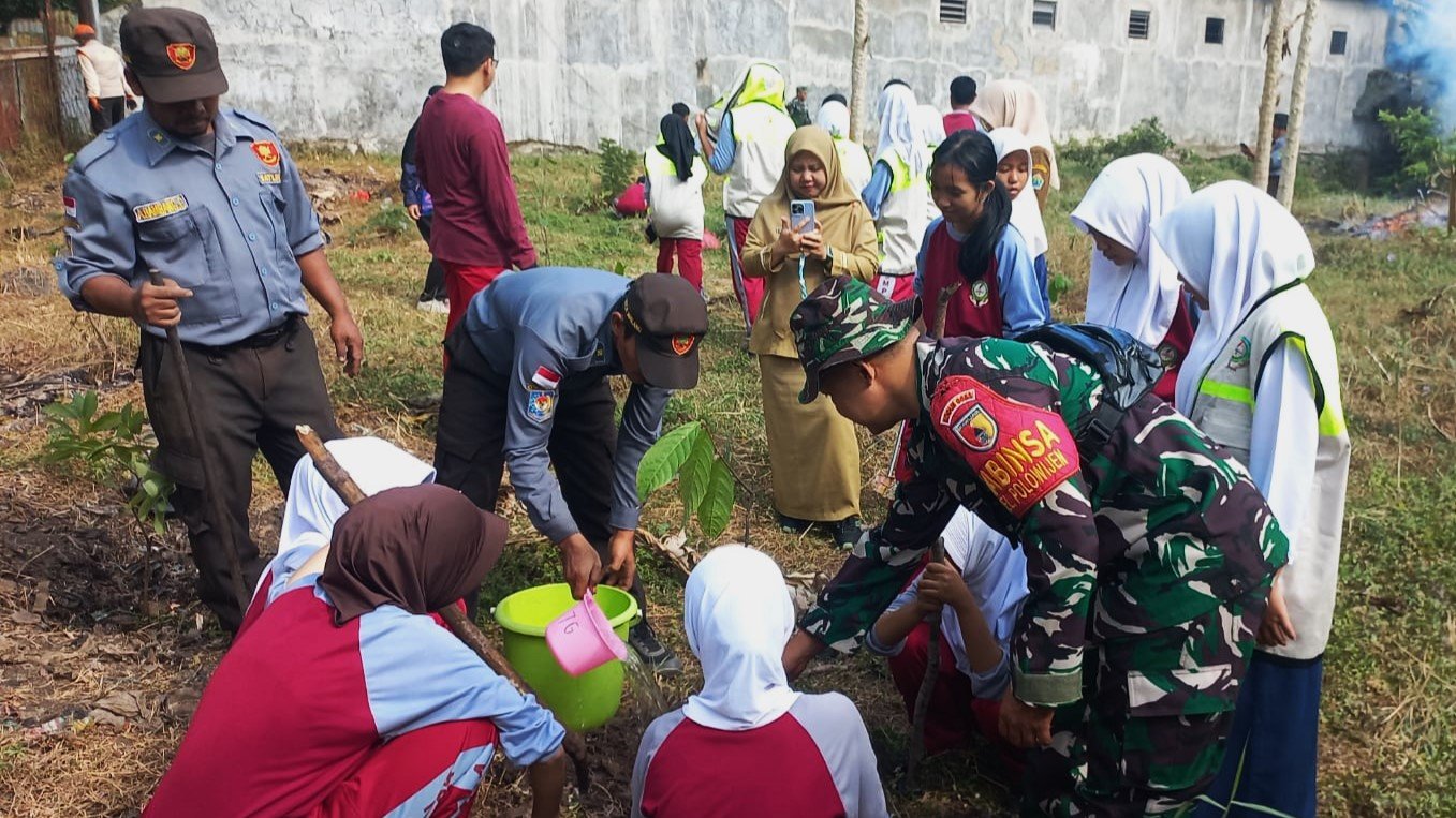 Momen kebersamaan personel Koramil 0833-03/Blimbing bersama petugas Linmas dan siswa-siswi SMPN 24 Malang saat bergotong royong menanam bibit pohon di Kelurahan Polowijen sebagai wujud aksi Karya Bakti memperingati HUT ke-81 TNI.