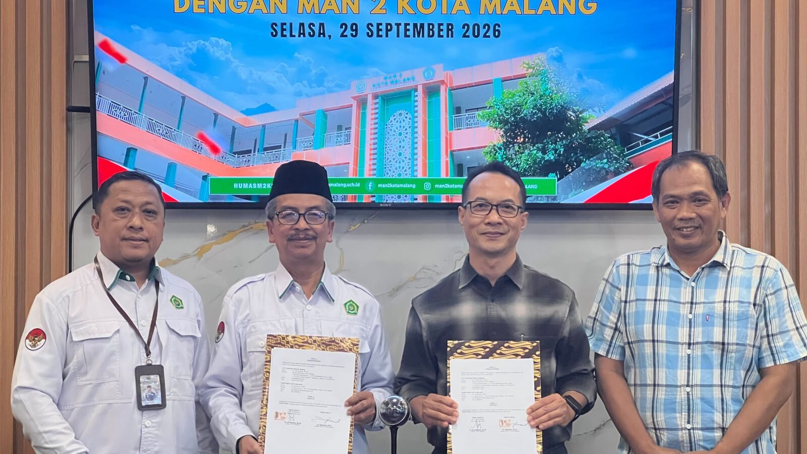 Kepala MAN 2 Kota Malang Dr. H. Samsudin, M.Pd. (kedua dari kiri) bersama Ketua JLPT Malang Dr. Aji Setyanto, M.Litt. (kedua dari kanan) menunjukkan berkas Perjanjian Kerja Sama (PKS) penyelenggaraan Ujian Kemampuan Bahasa Jepang di Ruang Kepala Madrasah, Selasa (29/9/2026).