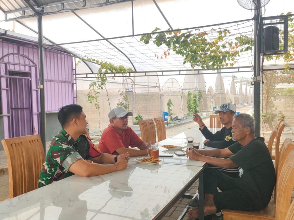 Babinsa Kelurahan Bareng, Serda Putu (kiri), tampak berbincang santai dan penuh keakraban bersama sejumlah tokoh masyarakat dalam kegiatan Komsos guna membahas keamanan dan ketertiban lingkungan, Kamis (10/09).