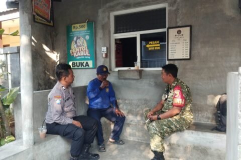 Potret keakraban Babinsa Tulusrejo, Serda Fajar, bersinergi bersama Bhabinkamtibmas saat menyempatkan diri berbincang santai dan mendengar aspirasi warga dalam kegiatan anjangsana kewilayahan, Sabtu (12/09).