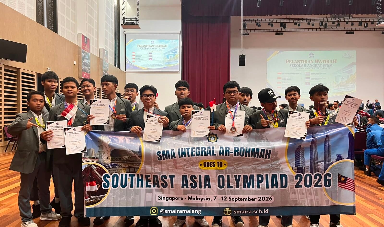 Wajah bangga para siswa delegasi SMA Integral Ar-Rohmah Malang saat membentangkan spanduk dan memamerkan deretan medali serta sertifikat penghargaan usai menaklukkan ajang Southeast Asia Olympiad 2026 di Malaysia.