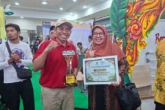Raut kebahagiaan perwakilan Kemenag Kota Malang saat memamerkan piala dan piagam penghargaan sebagai Terbaik 1 Karya Inovasi Stand Expo Madrasah Jawa Timur 2026 di Surabaya.