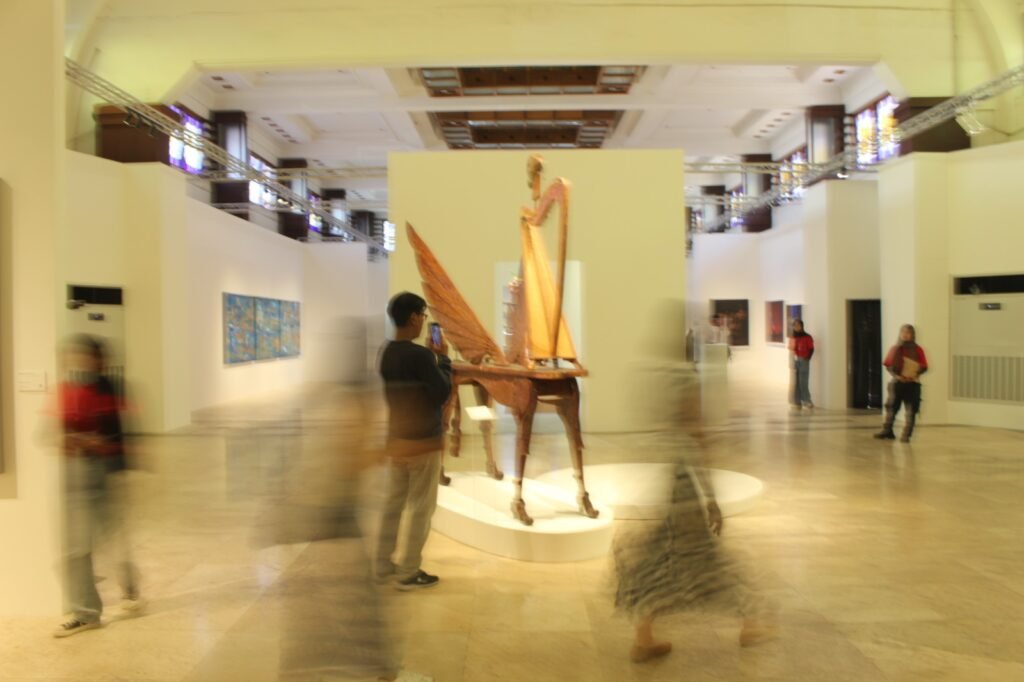 Suasana dinamis pengunjung saat mengapresiasi salah satu karya seni instalasi di ruang pameran.