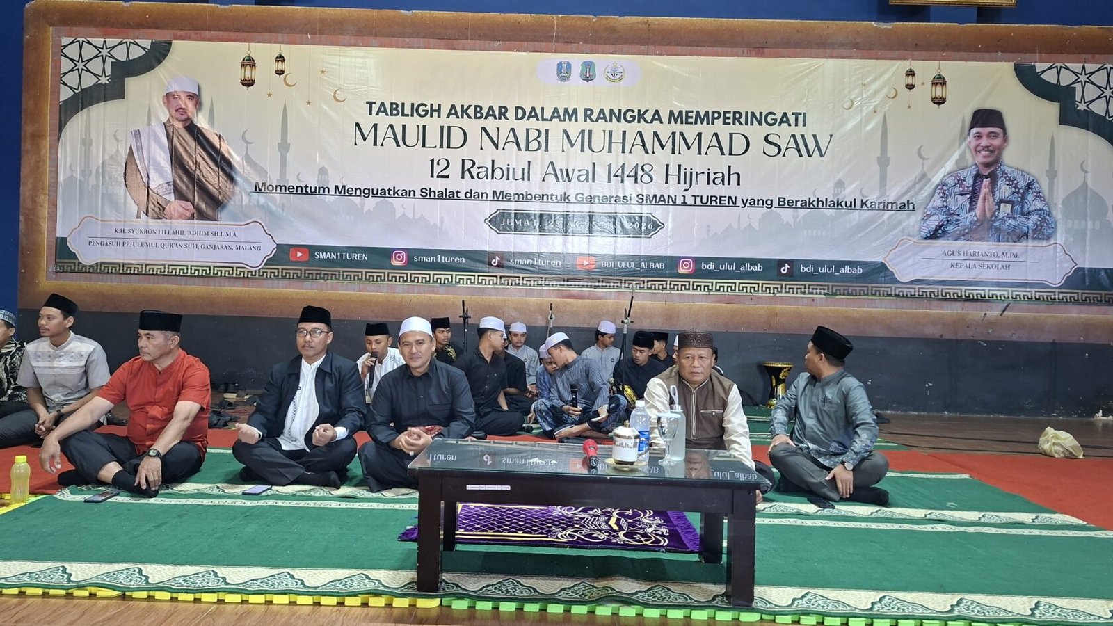 Suasana khidmat Tabligh Akbar dalam rangka memperingati Maulid Nabi Muhammad SAW 1448 H di SMAN 1 Turen. Tampak jajaran pimpinan sekolah dan tokoh agama duduk bersama di atas panggung mengikuti rangkaian acara.