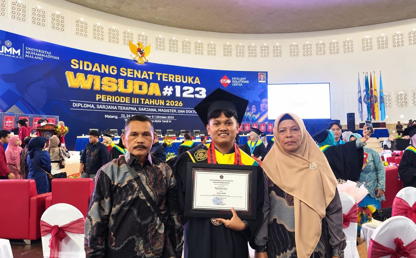 Rizal Ulil Azmi didampingi kedua orang tuanya tersenyum bangga memamerkan piagam penghargaan usai dinobatkan sebagai wisudawan terbaik Fakultas Hukum pada Wisuda ke-123 UMM di Hall Dome UMM, Malang.