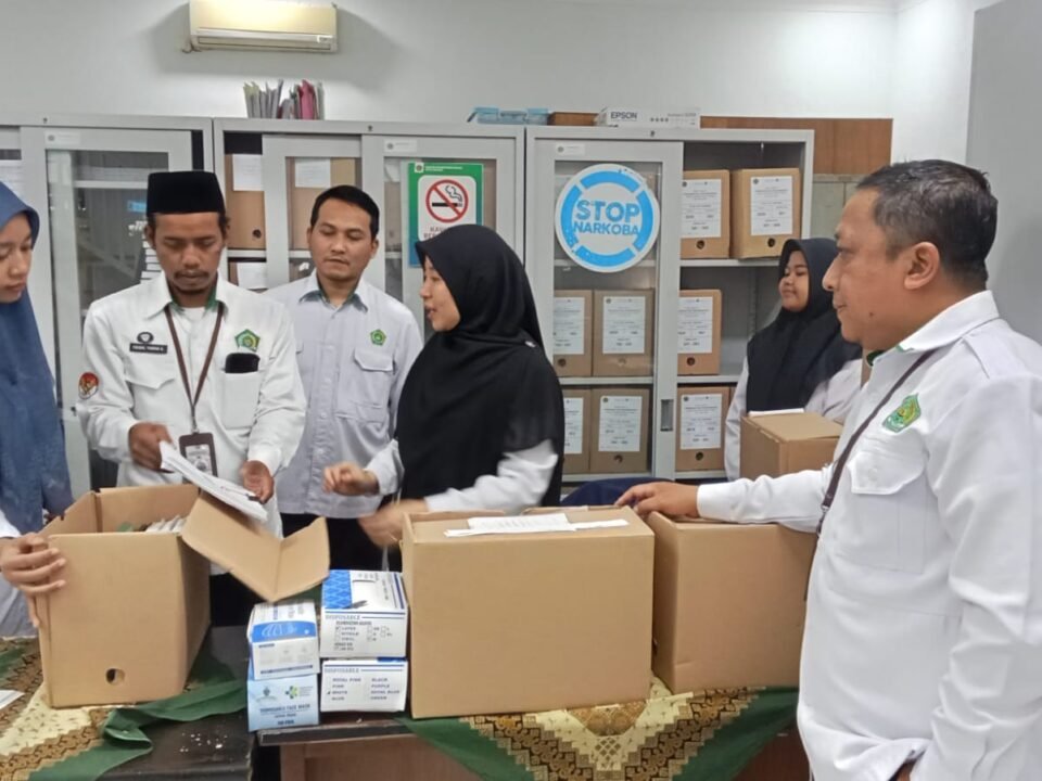 Kepala Tata Usaha MAN 2 Kota Malang, H. Sugeng Winarto (paling kanan), beserta Tim Arsiparis madrasah saat berdiskusi dan mengamati langsung proses penataan boks dokumen di Ruang Arsiparis Kantor Kemenag Kota Malang, Senin (14/9).