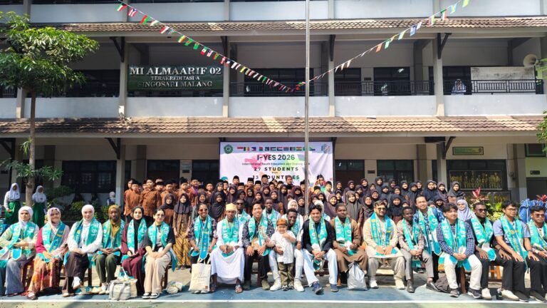 Mahasiswa internasional, dewan guru, dan para murid MTs Almaarif 01 Singosari bersama sekolah mitra berfoto bersama merayakan semarak kegiatan I-YES 2026 di halaman madrasah.