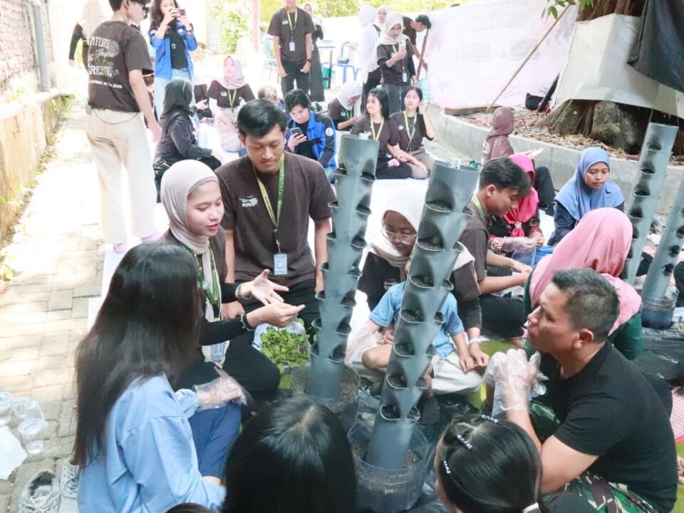 Kolaborasi antargenerasi dalam program MEA 2026: Mahasiswa KMTL FTAB UB dan warga RW 06 Tunjungsekar antusias mempelajari praktik penanaman pada model vertical garden berbahan pipa PVC, sebagai solusi penghijauan produktif di lahan sempit perkotaan.