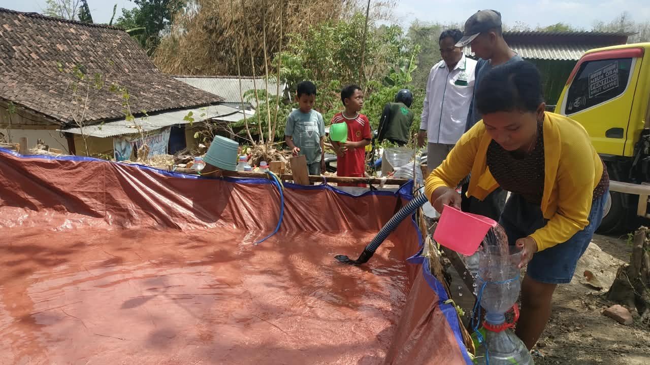 Warga Banyuurip menerima bantuan air bersih dari NU Care LAZISNU PCNU Kabupaten Ngawi dan MWCNU Kecamatan Ngawi, Minggu (18/10/2026)./dok.QONY