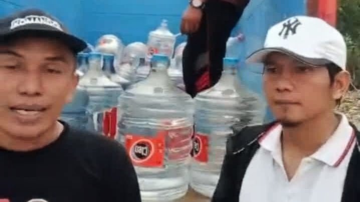 Gus Biyan pengurus NU CARE LAZISNU PCNU Kabupaten Ngawi dan UPZIS Kasreman bersama Suseno Kasi Pelayanan Desa Kiyonten saat penyaluran bantuan air minum 210 galon pada Selasa (20/10/2026)./dok.QONY