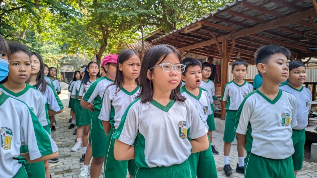 Siswa-siswi SD Katolik Santo Paulus Bojonegoro tampak fokus dan disiplin menyimak instruksi sebelum memulai rangkaian aktivitas fisik di Mbedidhink Outbound.