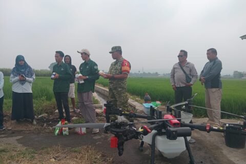 Babinsa Arjowinangun bersama tim PPL dan kelompok tani saat bersiap melakukan penyemprotan padi menggunakan drone.