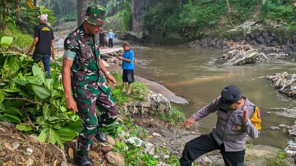Aparat bersama warga saat membersihkan bantaran Sungai Brantas