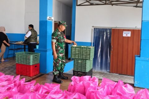 Babinsa Tlogomas Sertu Sugeng saat mendampingi proses penyiapan dan pengecekan paket makanan bergizi di wilayah binaan