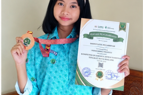 Potret membanggakan siswi berprestasi SMAN 6 Kota Malang saat menunjukkan medali dan piagam penghargaan kompetisi matematika nasional.