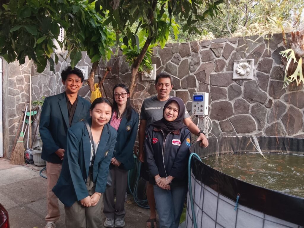 Mahasiswa FTAB UB bersama mitra pembudidaya UMKM Namazu Bites saat meninjau panel sistem monitoring kualitas air berbasis IoT di kolam budidaya lele, Tlogomas, Kota Malang.