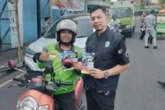 Tim Bapenda Jatim UPT. Pasuruan membagikan brosur sosialisasi program pemutihan pajak kepada pengendara ojek online di sekitar Stasiun Bangil