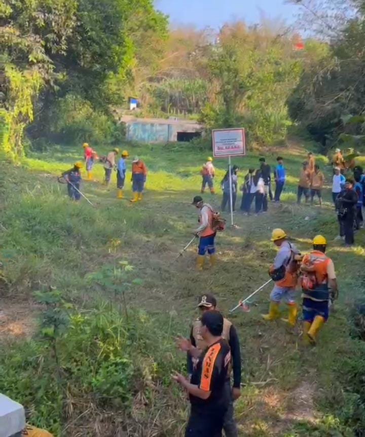 Petugas gabungan membersihkan semak dan merapikan rumput liar menggunakan mesin pemotong rumput di kawasan Sumber Merjosari sebagai persiapan World Cleanup Day (WCD).