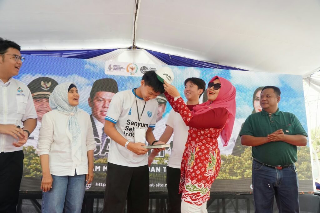 Penyerahan simbolis atribut dan cenderamata kepada perwakilan peserta dalam kegiatan peduli lingkungan.