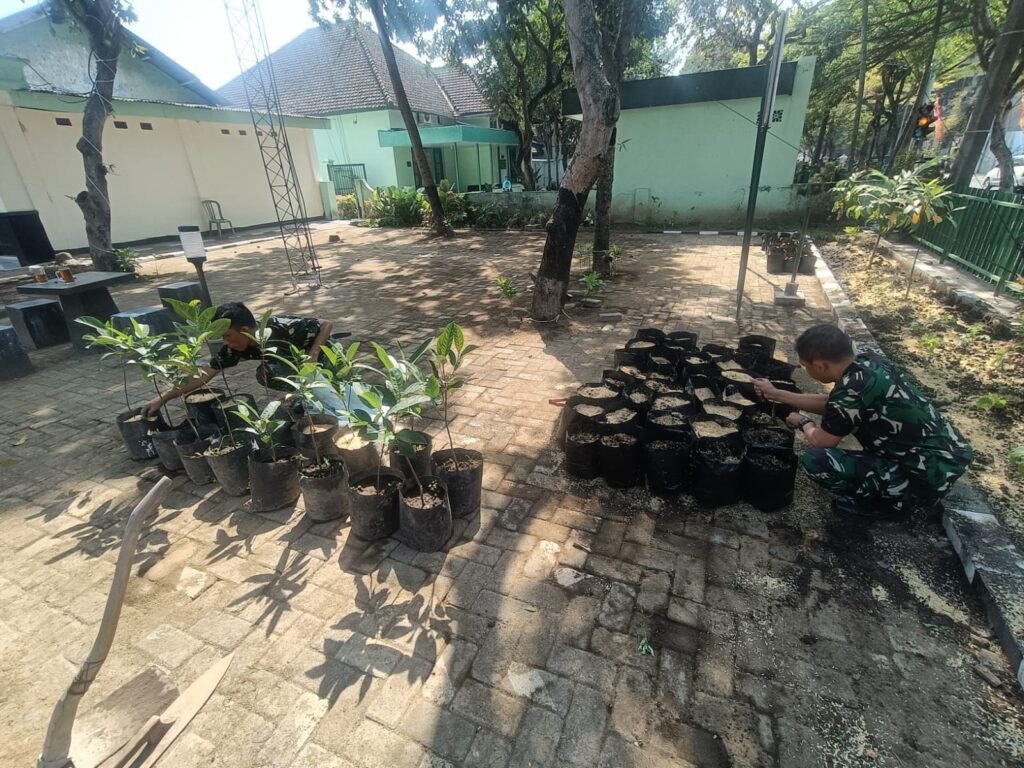 Personel Koramil 0833-01/Klojen memeriksa dan merapikan deretan polybag serta bibit pohon nangka sebelum disalurkan ke titik penanaman di wilayah binaan.