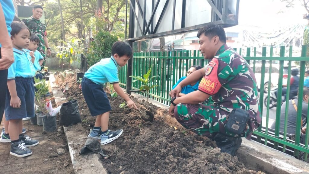 Prajurit Babinsa Koramil 0833-01/Klojen mendampingi siswa TK Kristen Calvin saat mempraktikkan cara menanam bibit pohon di area Makoramil Klojen, Kota Malang, Kamis (01/10/2026).
