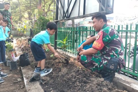 Prajurit Babinsa Koramil 0833-01/Klojen mendampingi siswa TK Kristen Calvin saat mempraktikkan cara menanam bibit pohon di area Makoramil Klojen, Kota Malang, Kamis (01/10/2026).
